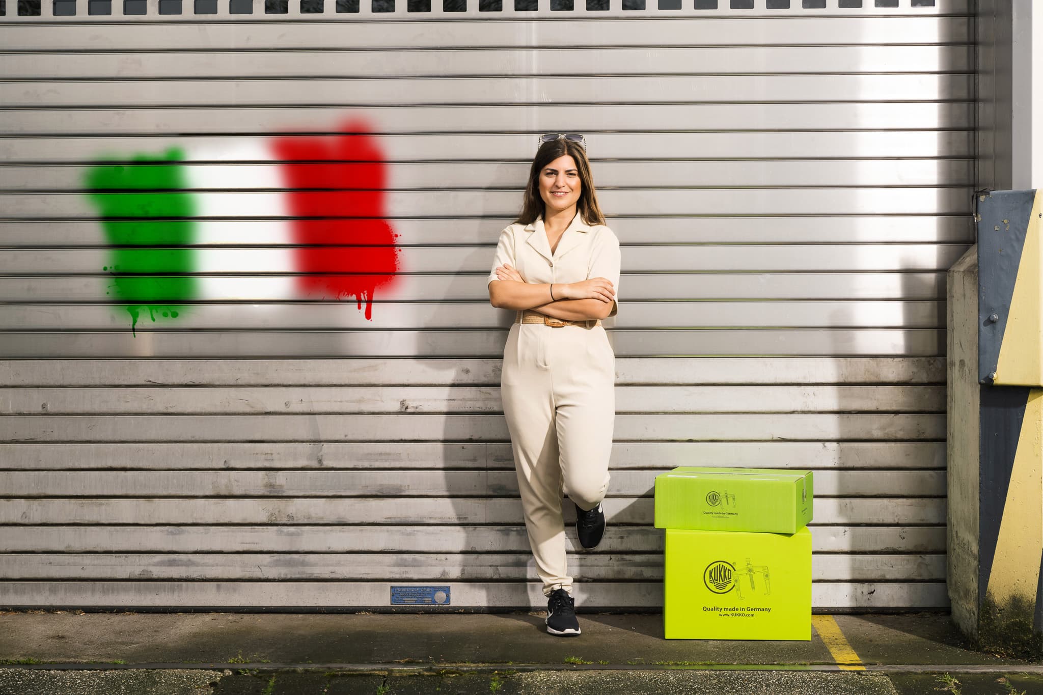 KUKKO Italia employee in front of rolling gate with Italian flag