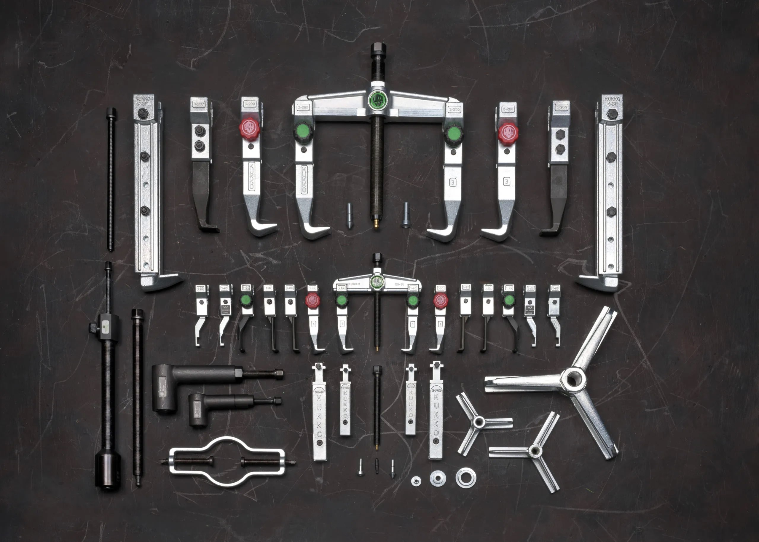 Various puller parts spread out on a grey background